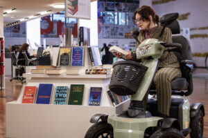 žena sedící na elektrickém invalidním čtyřkolovým skútru