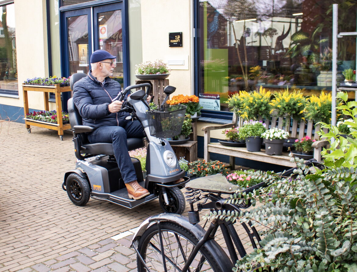 muž sedí na tříkolovém elektrickém skútru pro seniory